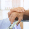 An image depicting an elderly person's hand being held by a medical professional. This picture is being used in an article that details the link between Alzheimer's and hearing loss